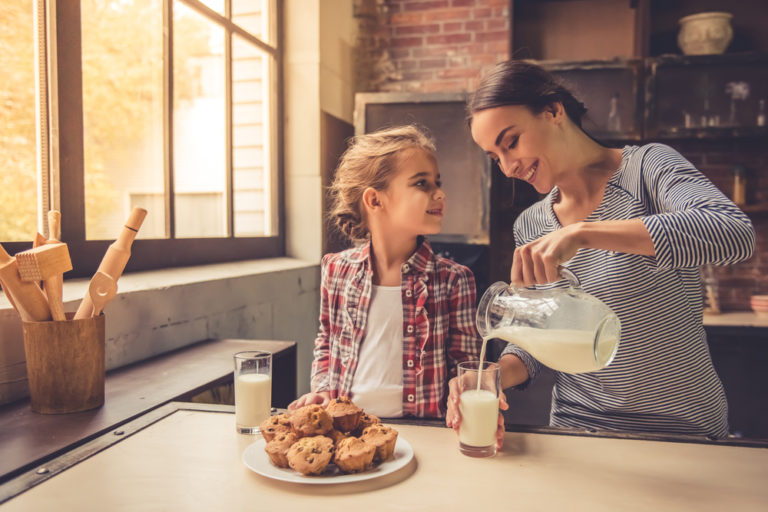 Perfect parent pours milk for daughter