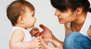 baby stimulation mom holds baby chin