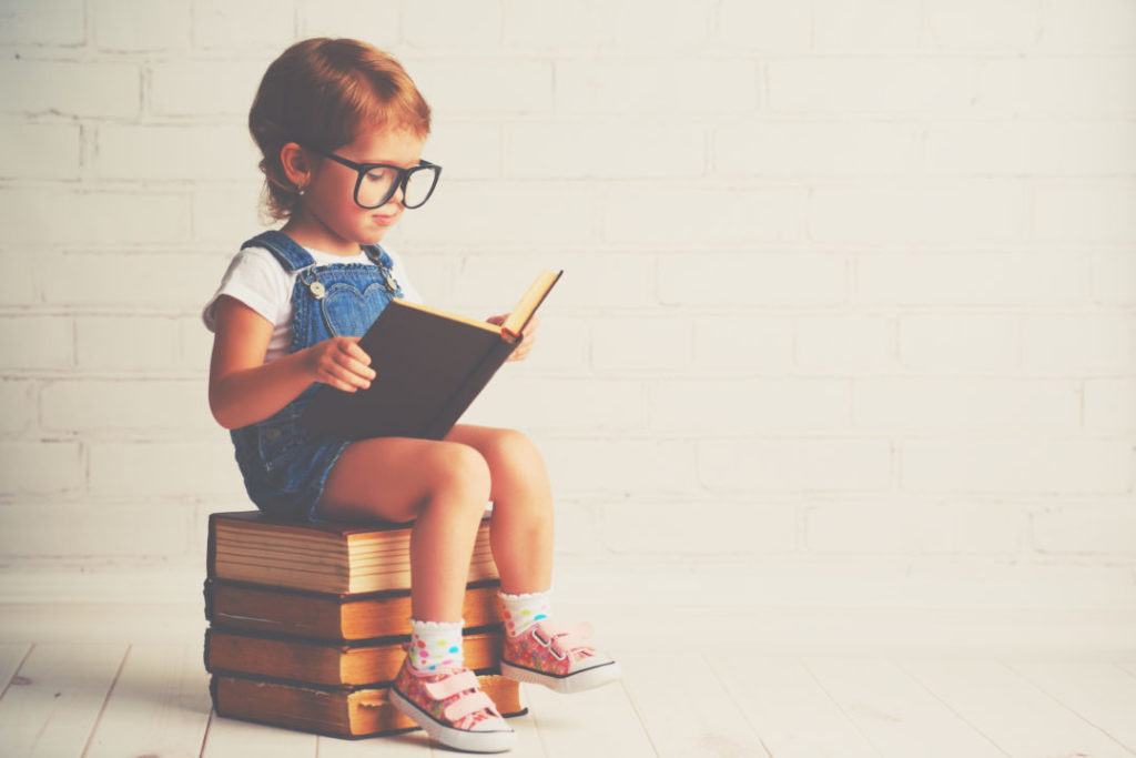 Growth mindset child reads with glasses