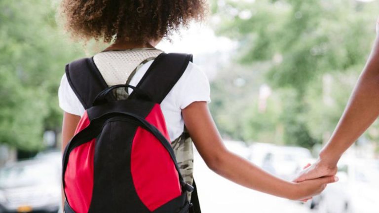 helicopter parents kid with rucksack holds hand of parent